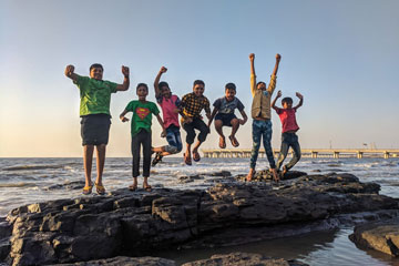 Kids jumping on a rock