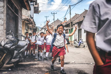 School kids running down a road